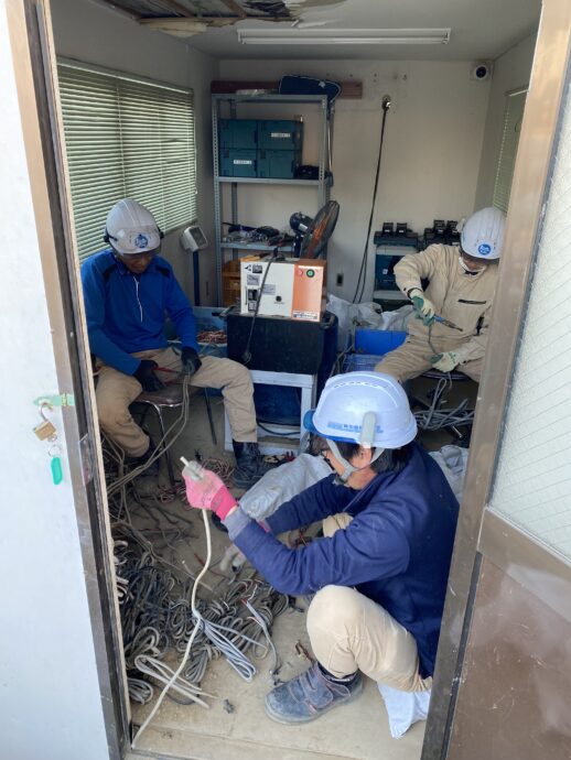 解体現場で回収した電線を手作業で仕分けする様子