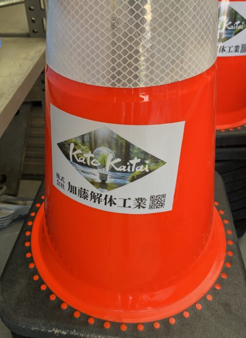 カラーコーンに貼られた会社ロゴシール