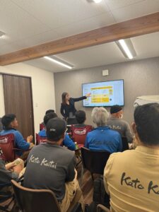 熱中症対策会議でスライドを使って説明を受ける社員と技能実習生