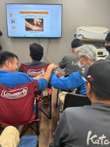 熱中症対策の説明中に笑顔で確認し合う日本人スタッフと技能実習生
