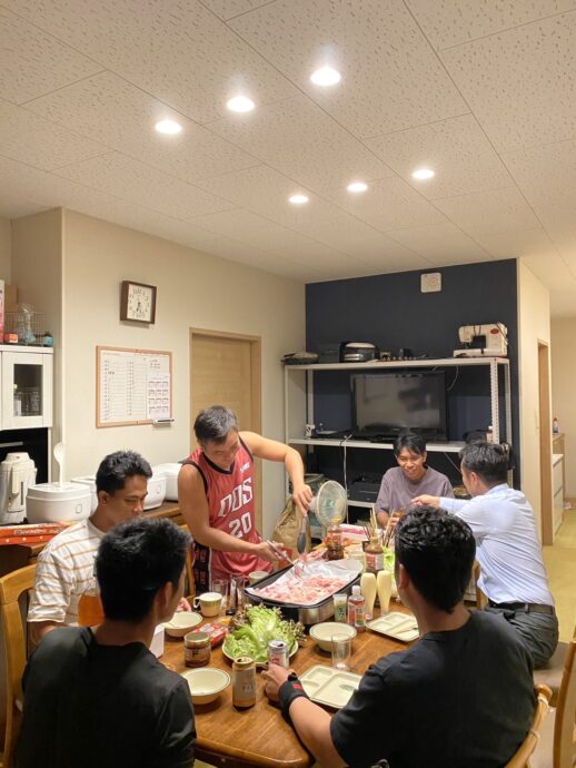 実習生と社長の焼肉パーティー|豊川市宿町 食卓を囲み、ホットプレートで肉を焼きながら食事を楽しむ実習生たちと社長